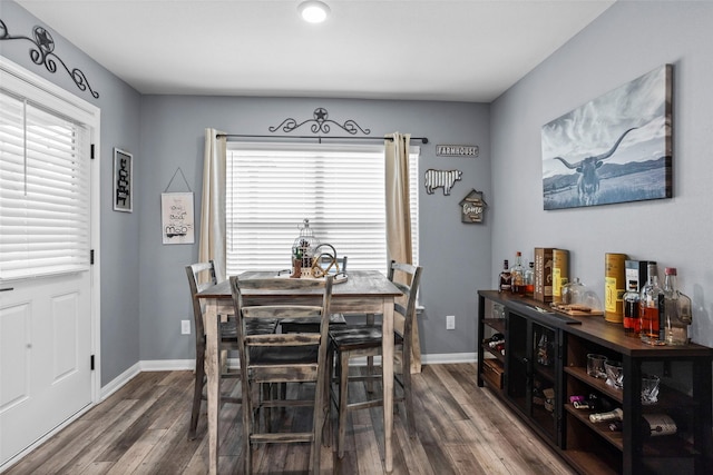 dining area featuring indoor bar and hardwood / wood-style flooring