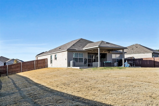 rear view of property with central AC, a lawn, and a patio