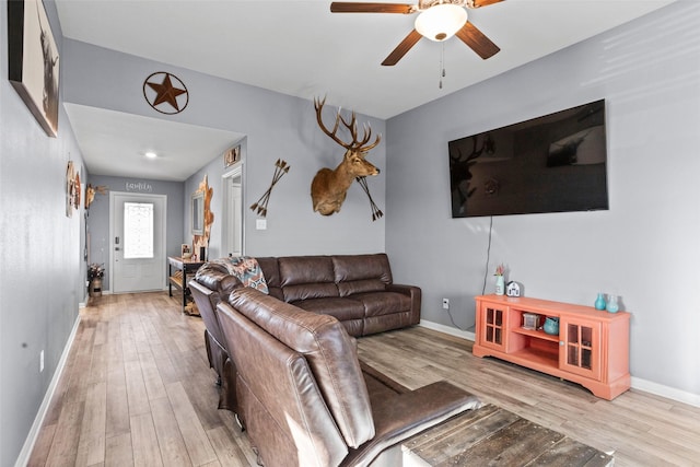 living room with light wood-type flooring and ceiling fan