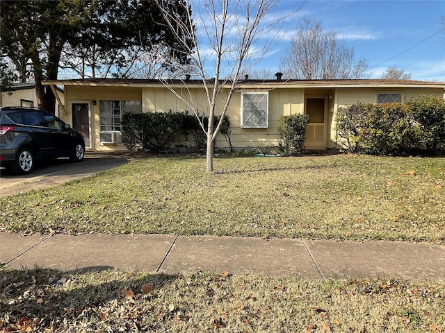 single story home with cooling unit and a front yard