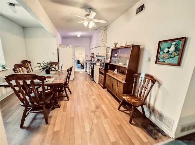 dining area with ceiling fan and light hardwood / wood-style flooring