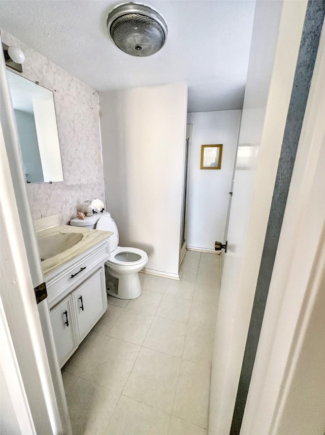 bathroom with toilet, a textured ceiling, walk in shower, and vanity