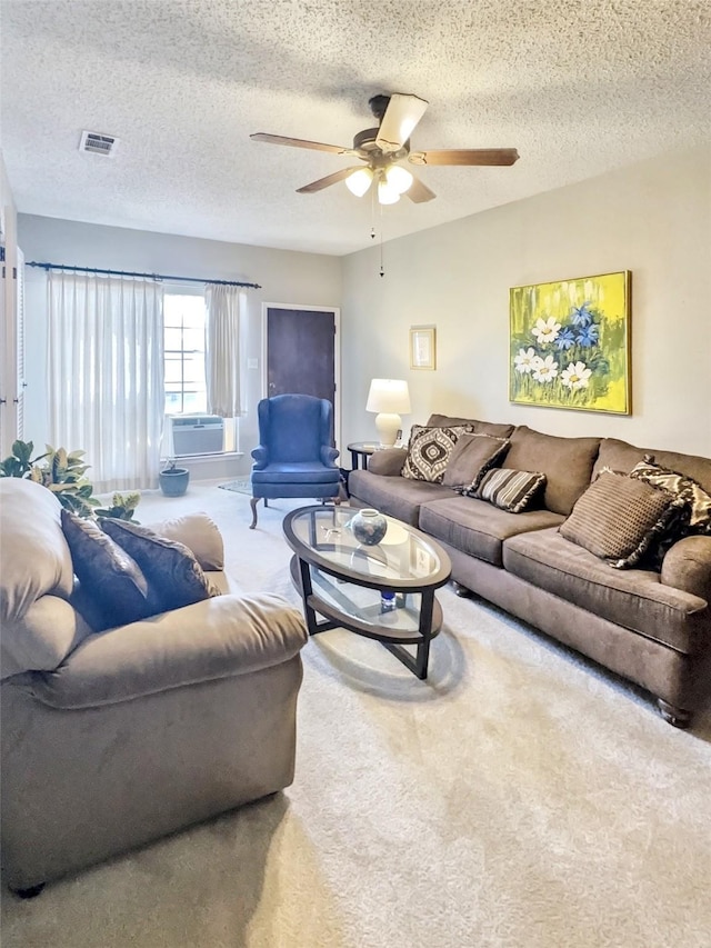 carpeted living room featuring a textured ceiling and ceiling fan