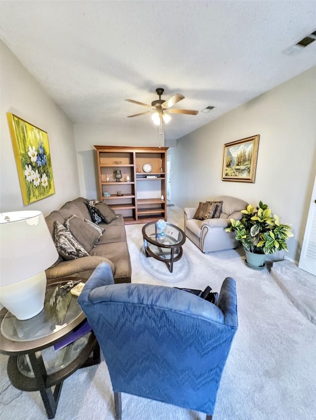 living room with ceiling fan, carpet, and a textured ceiling