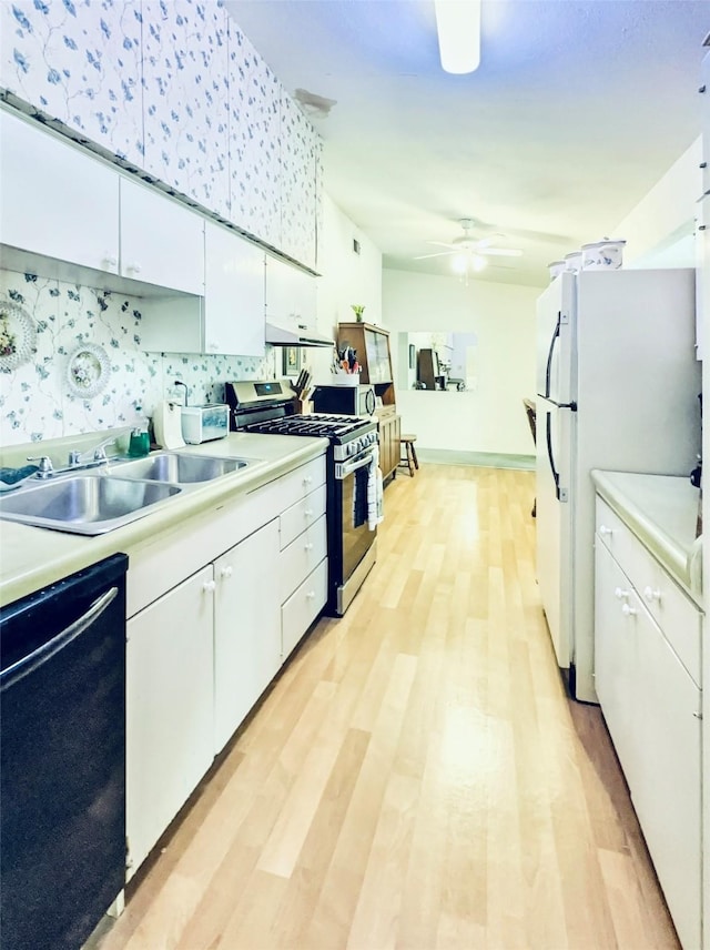 kitchen with black dishwasher, tasteful backsplash, stainless steel gas stove, white cabinets, and sink