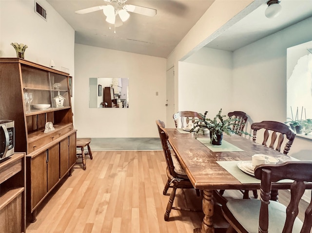 dining space featuring lofted ceiling, ceiling fan, and light hardwood / wood-style floors