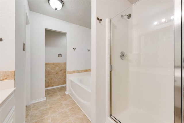 bathroom featuring a textured ceiling, shower with separate bathtub, and tile patterned flooring