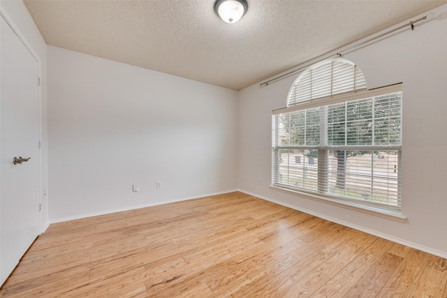 spare room with a textured ceiling and hardwood / wood-style flooring