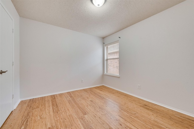 unfurnished room with light hardwood / wood-style floors and a textured ceiling