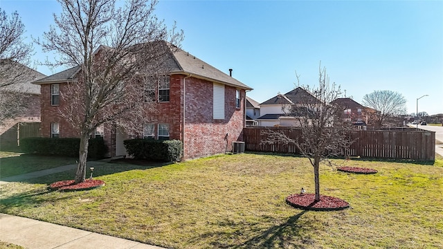 view of side of property with a lawn and cooling unit