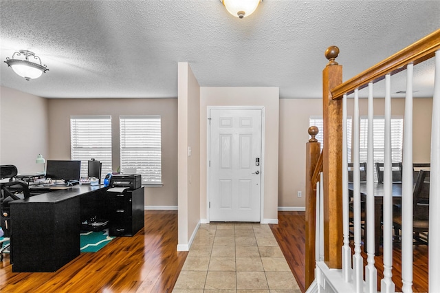 tiled foyer entrance featuring a textured ceiling and plenty of natural light