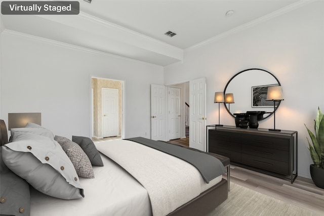 bedroom featuring crown molding and light hardwood / wood-style flooring