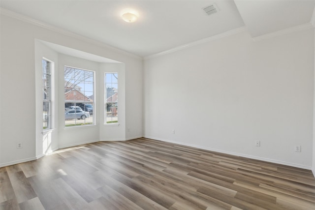 empty room with hardwood / wood-style flooring and ornamental molding