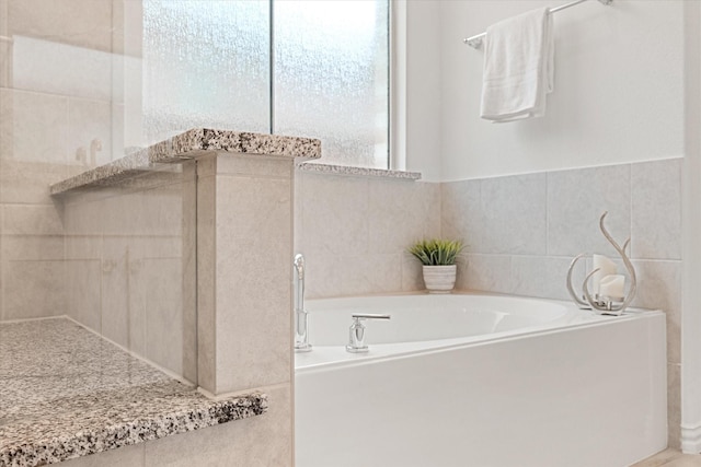 bathroom featuring tile walls and a bathing tub