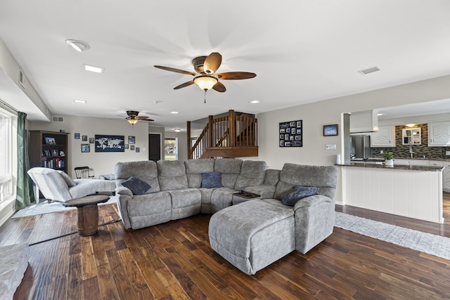 living room featuring visible vents, dark wood finished floors, stairway, and ceiling fan