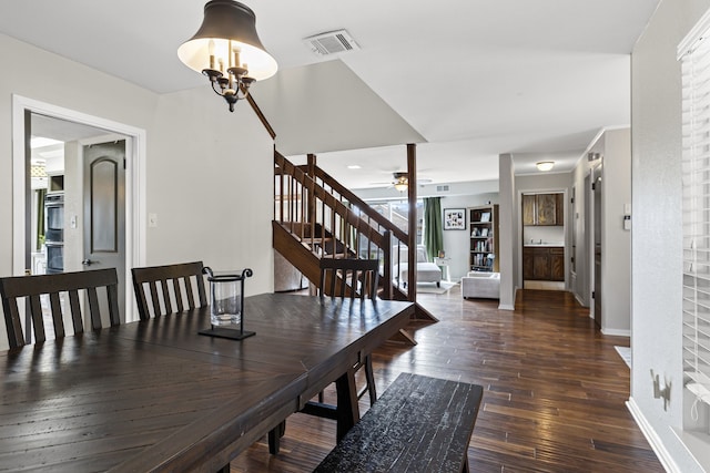 dining room featuring visible vents, stairway, baseboards, and hardwood / wood-style flooring