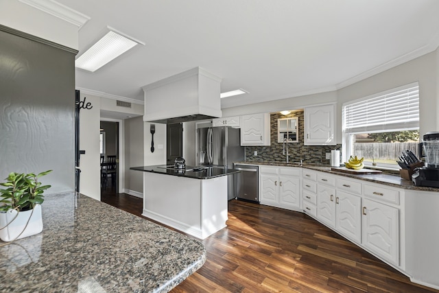 kitchen with sink, dark wood-type flooring, white cabinetry, stainless steel appliances, and tasteful backsplash