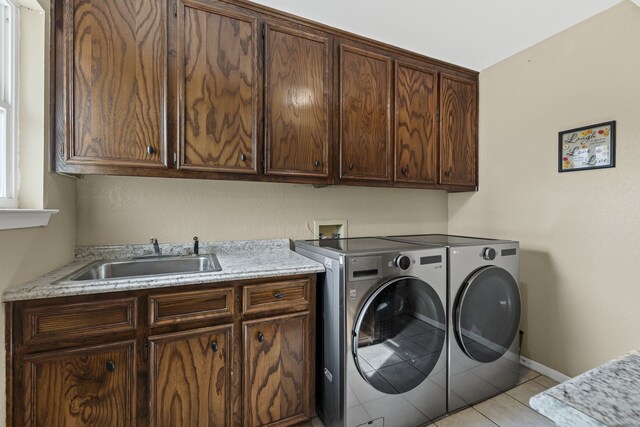 laundry area featuring cabinets, washer and dryer, sink, and light tile patterned floors