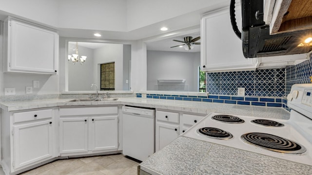 kitchen with kitchen peninsula, sink, white appliances, white cabinets, and ceiling fan with notable chandelier