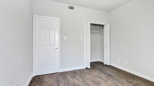 unfurnished bedroom featuring dark hardwood / wood-style flooring and a closet