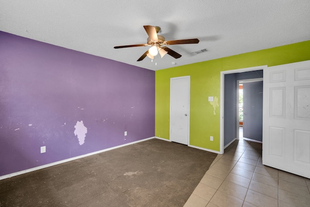 unfurnished bedroom with ceiling fan, tile patterned floors, and a textured ceiling