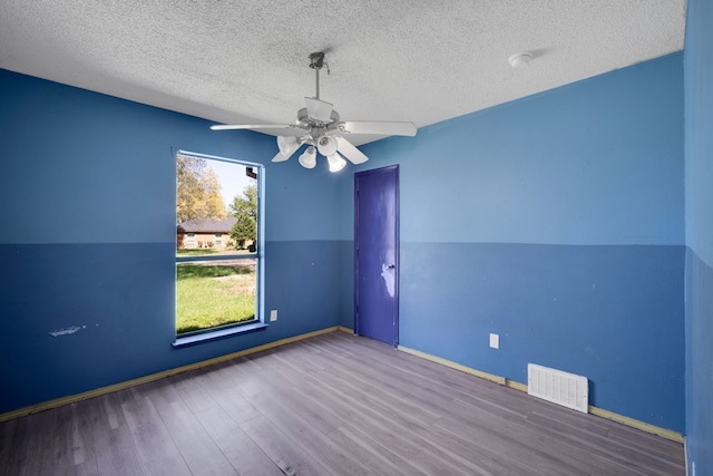 spare room featuring vaulted ceiling, ceiling fan, a textured ceiling, and hardwood / wood-style floors