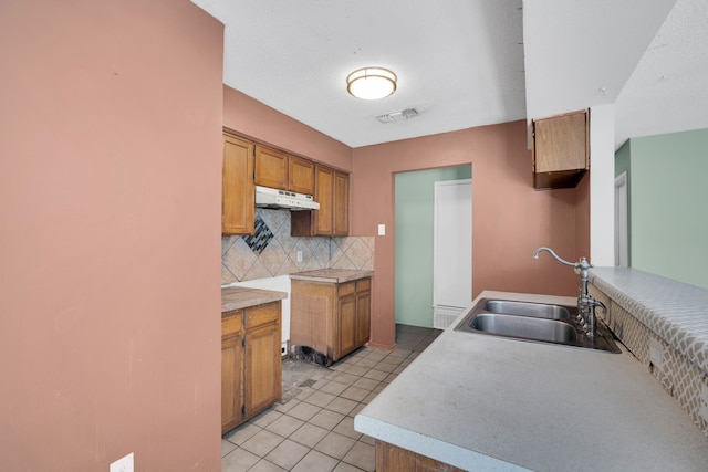 kitchen featuring sink, backsplash, and light tile patterned floors