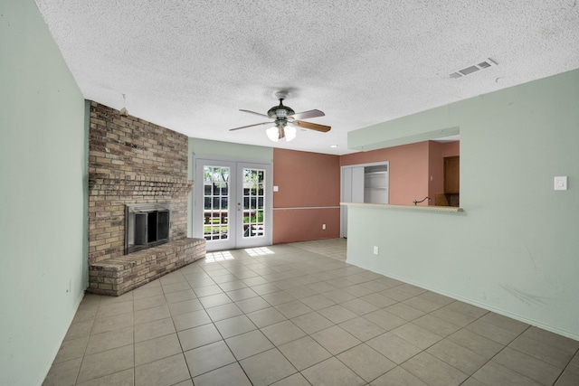 unfurnished living room with ceiling fan, a textured ceiling, light tile patterned floors, and french doors