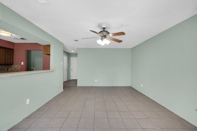 tiled empty room featuring ceiling fan