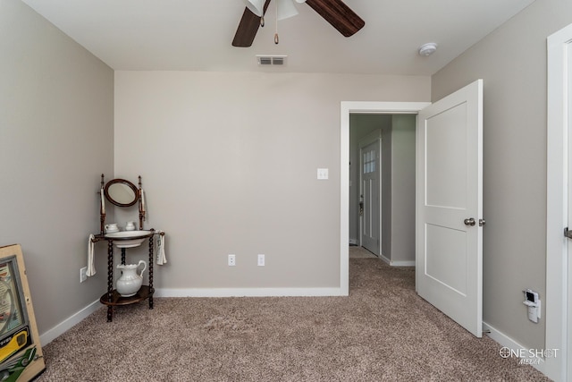 spare room with ceiling fan and carpet