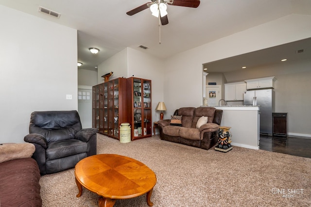 living room featuring ceiling fan, sink, and carpet