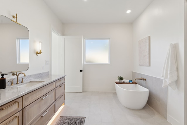 bathroom featuring vanity, a wealth of natural light, and a bathing tub