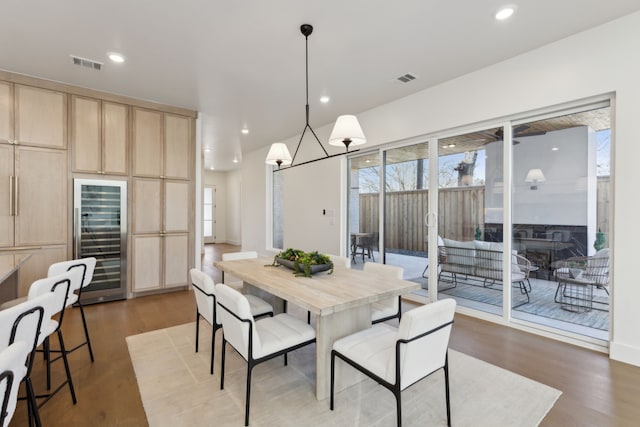 dining space featuring wine cooler and hardwood / wood-style flooring