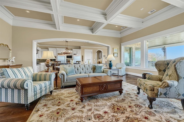 living room featuring beam ceiling, coffered ceiling, and a notable chandelier