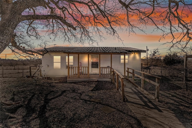 back house at dusk with covered porch