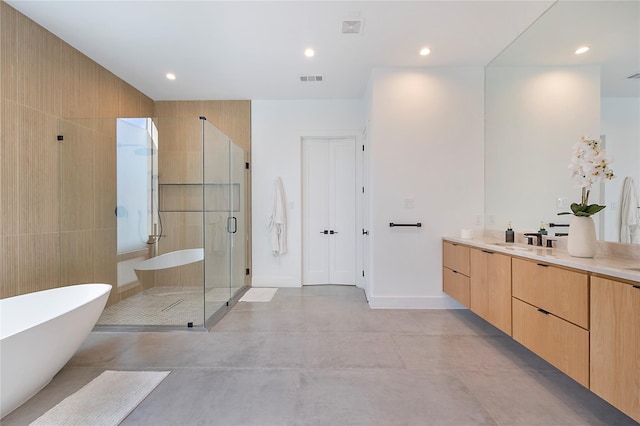 bathroom with concrete floors, vanity, and independent shower and bath