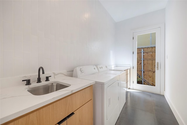 laundry area featuring cabinets, sink, dark tile patterned flooring, and washer and clothes dryer