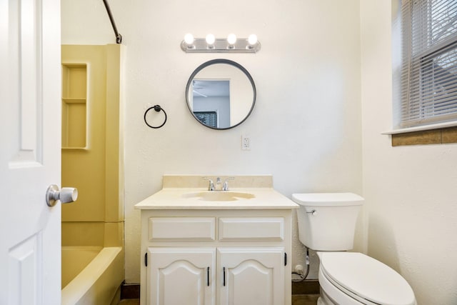 bathroom with toilet, a tub to relax in, and vanity