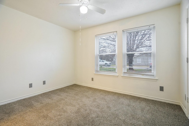 carpeted spare room featuring ceiling fan