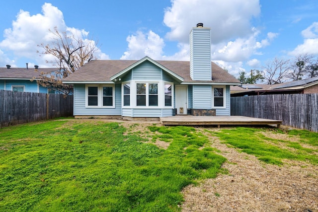 back of house featuring a deck and a yard