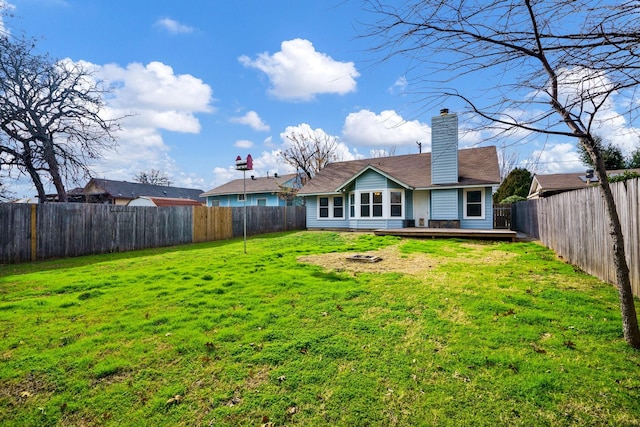 back of property with a deck and a yard