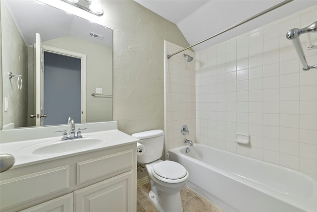 bathroom with a textured wall, visible vents, and vaulted ceiling