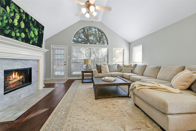 living room featuring hardwood / wood-style flooring, a fireplace, high vaulted ceiling, and ceiling fan