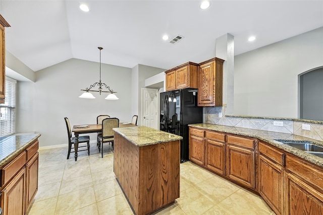 kitchen featuring visible vents, light stone counters, backsplash, black fridge with ice dispenser, and lofted ceiling