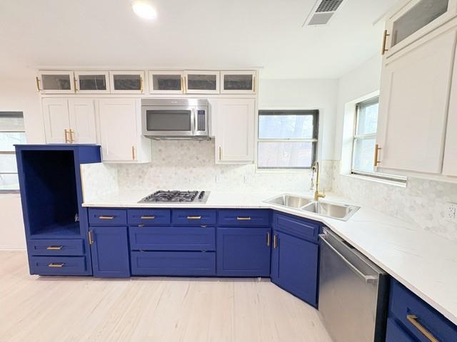 kitchen with sink, white cabinetry, appliances with stainless steel finishes, and blue cabinets