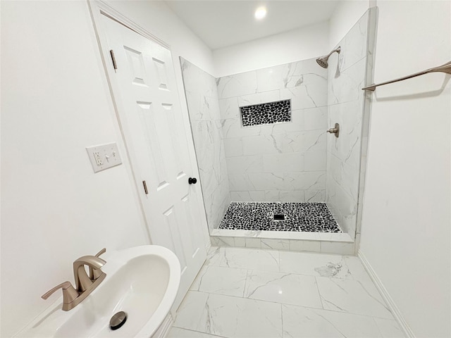 bathroom with a shower stall, baseboards, marble finish floor, and a sink