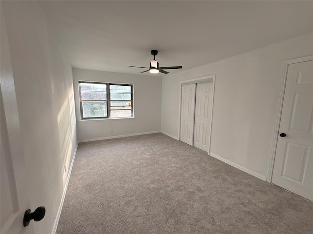 unfurnished bedroom with baseboards, carpet floors, a closet, and ceiling fan