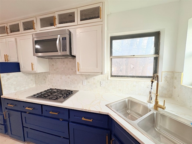 kitchen featuring tasteful backsplash, sink, white cabinetry, and stainless steel appliances