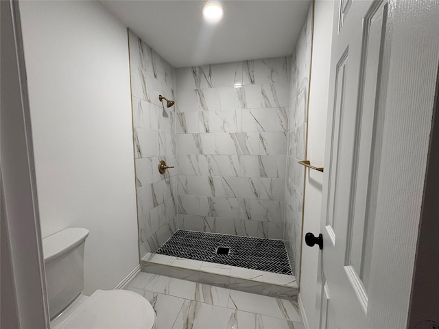 bathroom with toilet and a tile shower