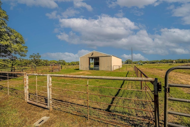 view of gate with an outbuilding and a rural view